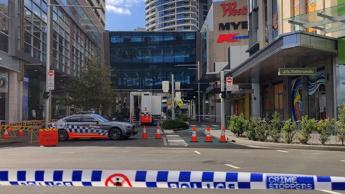 Policejní auto postává u nákupního centra v Sydney, kde došlo k útoku nožem.