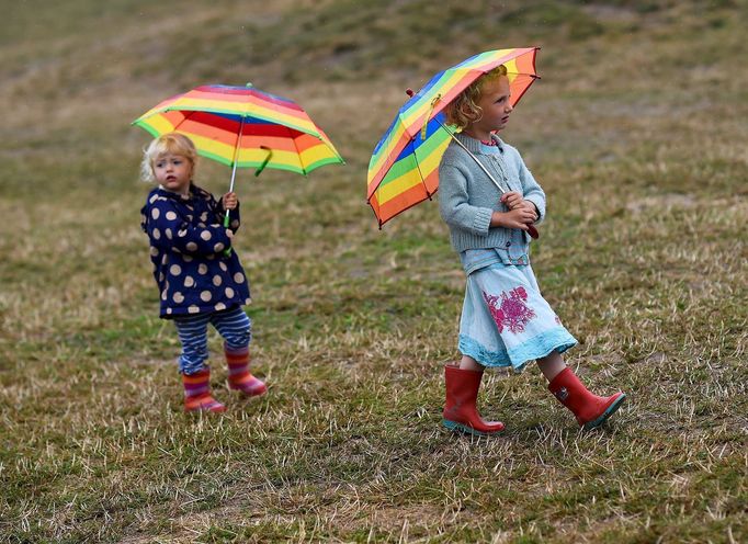 Sisters walk in the rain at Worthy Farm in Somerset during the Glastonbury Festival