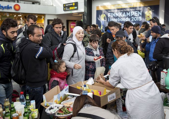 Švédští dobrovolníci distribuují pomoc uprchlíkům.