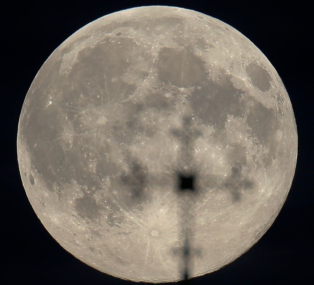 The supermoon is seen behind a cross of an Orthodox church in Minsk