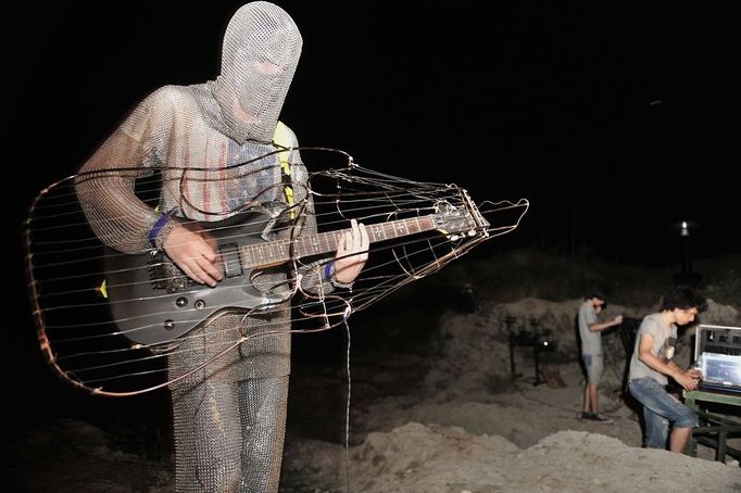 Performing With Lightning CHANGLE, CHINA - AUGUST 13: (CHINA OUT) A guitarist prepares to play guitar with a Tesla coil transformer during a stunt performance on August 13, 2012 in Changle, Fujian Province of China. Wang Zengxiang, one of the craziest fans of the Tesla coil stunt, has dedicated himself in the daredevil career for a decade. He is now the leader of a band of four. A Tesla coil is an electrical resonant transformer circuit invented by Nikola Tesla around 1891. The transformer produces high voltage at high frequencies, which acts as a giant lightning machine, and creates long bolts of electricity. Shielded by protective clothing, the performer is insulated from the electricity current which dissipates through the ground. ( automatický překlad do češtiny )