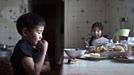 Nikolay Vinokurov, 7, and his sister Vera Vinokurova, 9, have lunch at their grandmother's house in the village of Tomtor, in the Republic of Sakha, northeast Russia, January 21, 2013. The coldest temperatures in the northern hemisphere have been recorded in Sakha, the location of the Oymyakon valley, where according to the United Kingdom Met Office a temperature of -67.8 degrees Celsius (-90 degrees Fahrenheit) was registered in 1933 - the coldest on record in the northern hemisphere since the beginning of the 20th century. Yet despite the harsh climate, people live in the valley, and the area is equipped with schools, a post office, a bank, and even an airport runway (albeit open only in the summer). Picture taken January 21, 2013. REUTERS/Maxim Shemetov (RUSSIA - Tags: SOCIETY FOOD ENVIRONMENT) ATTENTION EDITORS: PICTURE 15 OF 27 FOR PACKAGE 'THE POLE OF COLD' SEARCH 'MAXIM COLD' FOR ALL IMAGES Published: Úno. 18, 2013, 11:26 dop.