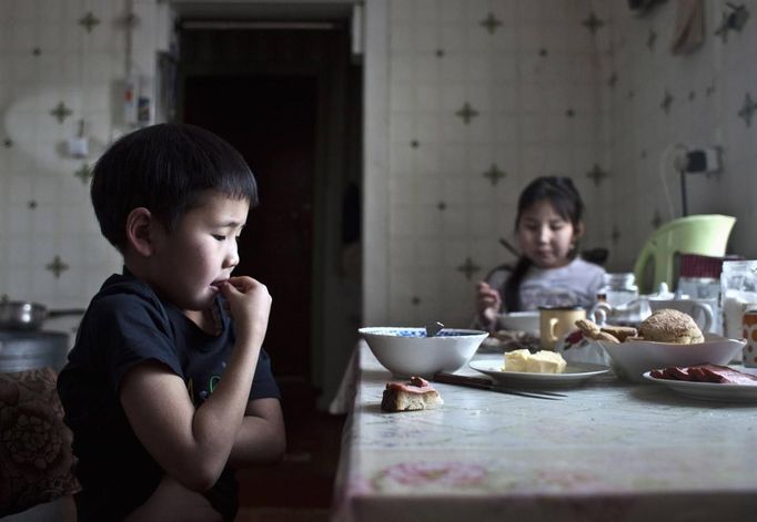 Nikolay Vinokurov, 7, and his sister Vera Vinokurova, 9, have lunch at their grandmother's house in the village of Tomtor, in the Republic of Sakha, northeast Russia, January 21, 2013. The coldest temperatures in the northern hemisphere have been recorded in Sakha, the location of the Oymyakon valley, where according to the United Kingdom Met Office a temperature of -67.8 degrees Celsius (-90 degrees Fahrenheit) was registered in 1933 - the coldest on record in the northern hemisphere since the beginning of the 20th century. Yet despite the harsh climate, people live in the valley, and the area is equipped with schools, a post office, a bank, and even an airport runway (albeit open only in the summer). Picture taken January 21, 2013. REUTERS/Maxim Shemetov (RUSSIA - Tags: SOCIETY FOOD ENVIRONMENT) ATTENTION EDITORS: PICTURE 15 OF 27 FOR PACKAGE 'THE POLE OF COLD' SEARCH 'MAXIM COLD' FOR ALL IMAGES Published: Úno. 18, 2013, 11:26 dop.