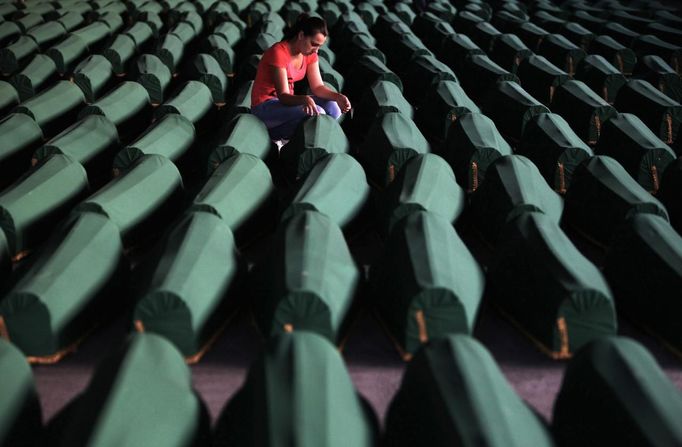 A Bosnian Muslim girl touches the coffin of her relative which was prepared for a mass burial at the Memorial Center in Potocari, near Srebrenica July 9, 2012. The bodies of 520 recently identified victims of the Srebrenica massacre will be buried on July 11, the anniversary of the massacre when Bosnian Serb forces commanded by Ratko Mladic slaughtered 8,000 Muslim men and boys and buried them in mass graves, in Europe's worst massacre since World War Two. REUTERS/Dado Ruvic (BOSNIA - Tags: POLITICS CONFLICT ANNIVERSARY TPX IMAGES OF THE DAY) Published: Čec. 9, 2012, 6:38 odp.