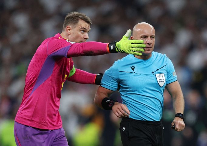 Kapitán Bayernu Manuel Neuer marně reklamuje u Szymona Marciniaka chybný výrok