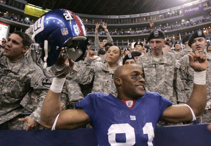 Amani Toomer z týmu New York Giants se raduje spolu s americkými vojáky v hledišti stadiónu Dallas Cowboys v texaském Irvingu po jednom z touchdownů ve vítězném čtvrtfinálovém zápase