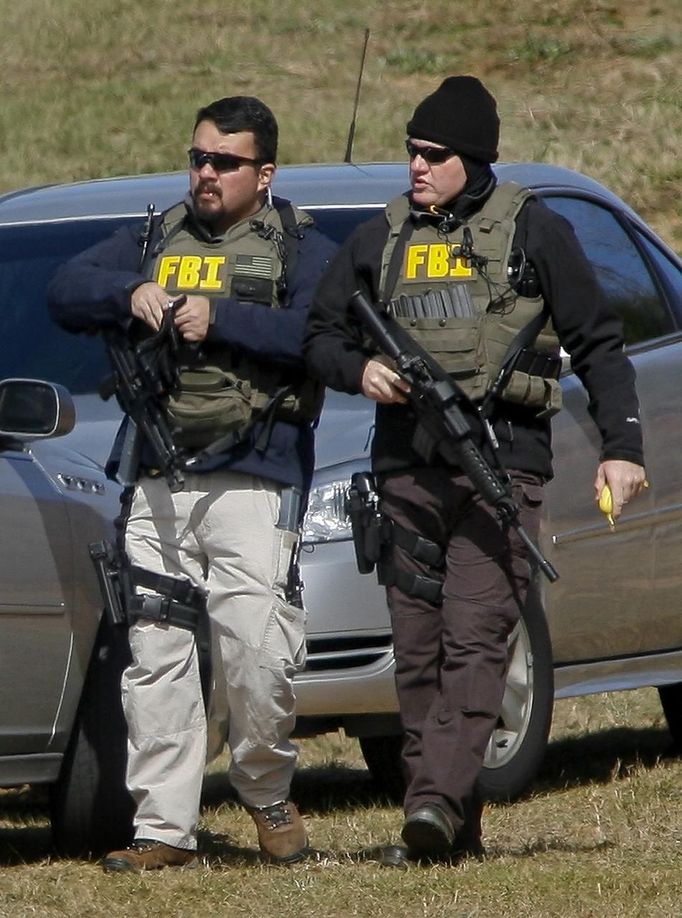 Law enforcement officials from the FBI walk near the scene of a shooting and hostage taking near Midland City, Alabama February 1, 2013. Residents in a rural Alabama town prayed on Friday and called for the release of a 5-year-old boy being held captive for a fourth day by a man accused of shooting a school bus driver and then taking the child hostage. REUTERS/Phil Sears (UNITED STATES - Tags: CRIME LAW) Published: Úno. 1, 2013, 9:33 odp.