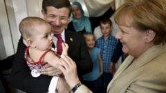 Turecký premiér Ahmet Davutoglu a německá kancléřka Angela Merkelová v uprchlickém táboře.