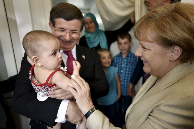 Turecký premiér Ahmet Davutoglu a německá kancléřka Angela Merkelová v uprchlickém táboře.