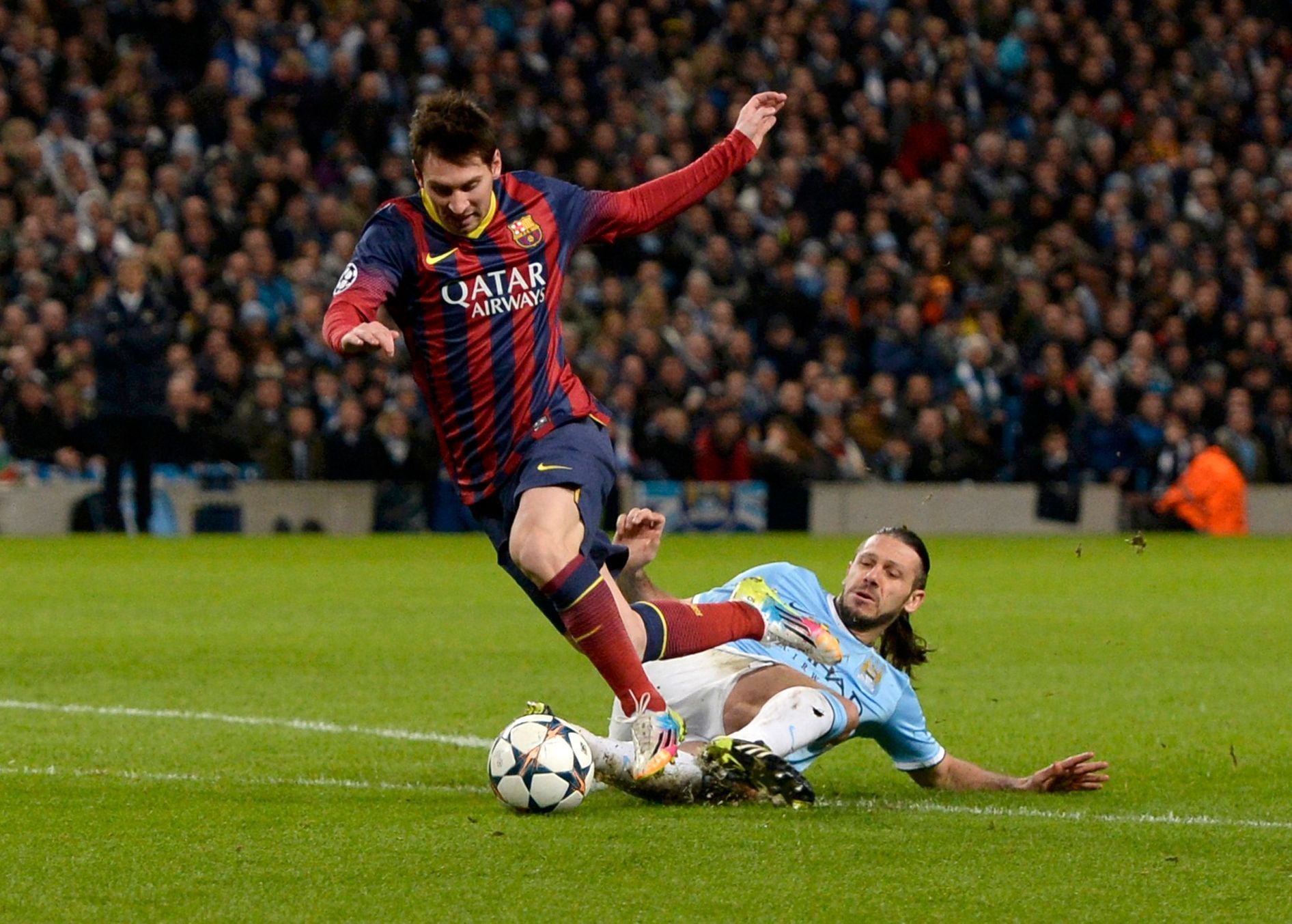 Manchester City's Martin Demichelis fouls Barcelona's Lionel Messi to concede a penalty during their Champions League round of 16 first leg soccer match at the Etihad Stadium in Manchester