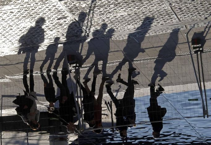 Passers-by are reflected in mirror panels designed by British architect Norman Foster as they walk at the Old Harbour in Marseille February 21, 2013. The installation will be inaugurated on March 2. REUTERS/Jean-Paul Pelissier (FRANCE - Tags: SOCIETY)