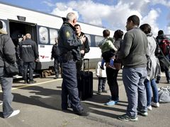 Uprchlíci debatují s policisty na dánské hranici.