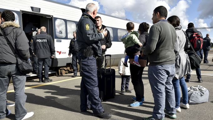 Uprchlíci debatují s policisty na dánské hranici.