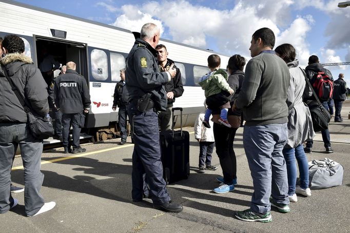 Uprchlíci debatují s policisty na dánské hranici.