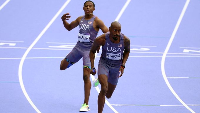 Americký atlet Quincy Wilson předává Vernonu Norwoodovi v závodě štafet na 4x400 m na OH 2024 v Paříži