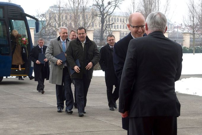 Premiér v demisi Jiří Rusnok (vpravo) vítá nového premiéra Bohuslava Sobotku před Úřadem vlády, kam premiér a jeho ministři zamířili 29. ledna 2014.