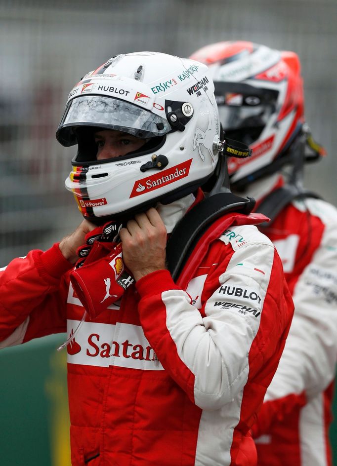 Ferrari Formula One driver Sebastian Vettel of Germany (L) walks ahead of team mate Kimi Raikkonen of Finland after the qualifying session of the Australian F1 Grand Prix