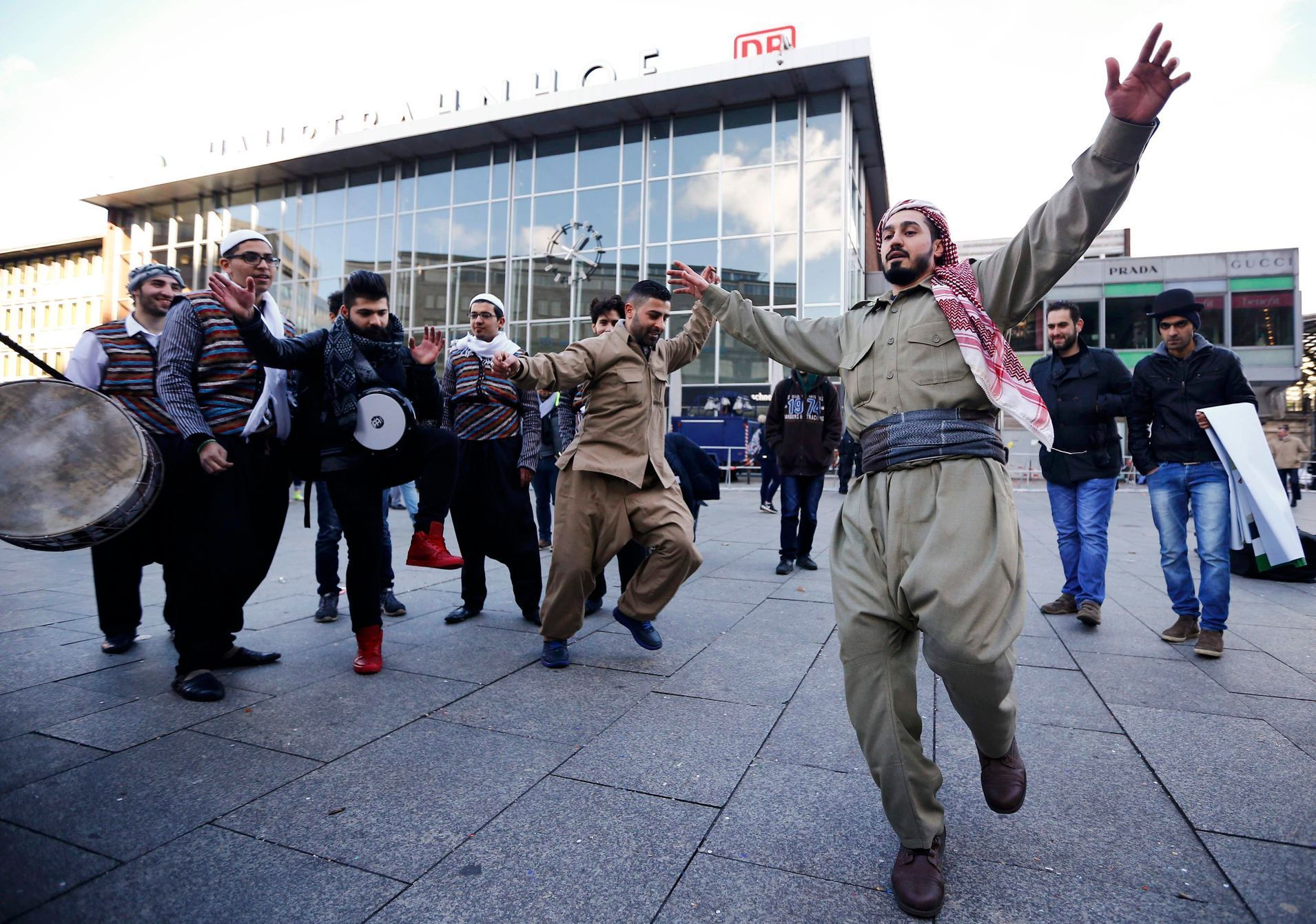 Uprchlíci tančí během karnevalu před budovou hlavního nádraží v Kolíně nad Rýnem.