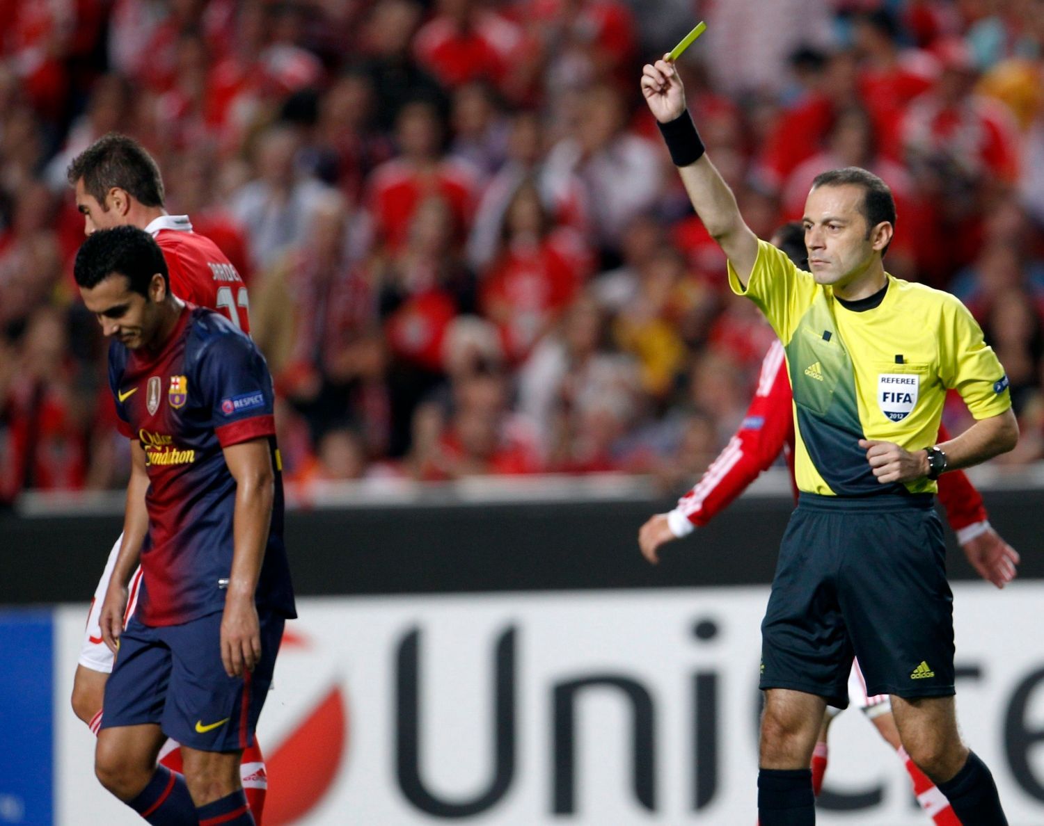 Fotbalista Barcelony Pedro Rodriguéz dostává žlutou kartu za filmování v utkání Ligy mistrů 2012/13 proti Benfice Lisabon.