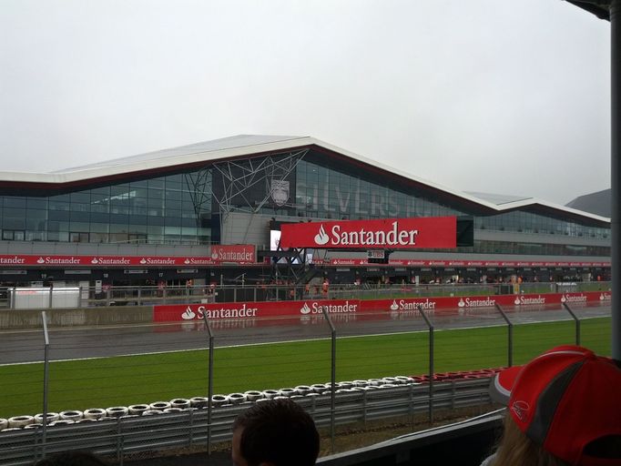 Pohled na moknoucí boxy v Silverstone ze zastřešené hlavní tribuny.