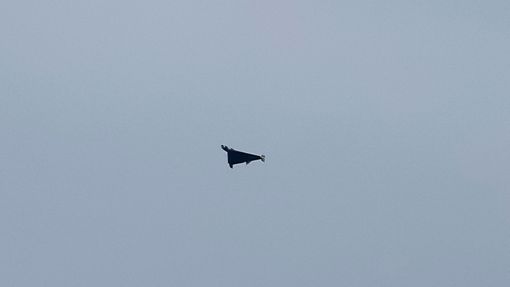 Ruský dron zachycený teleobjektivem při útoku na Kyjev.