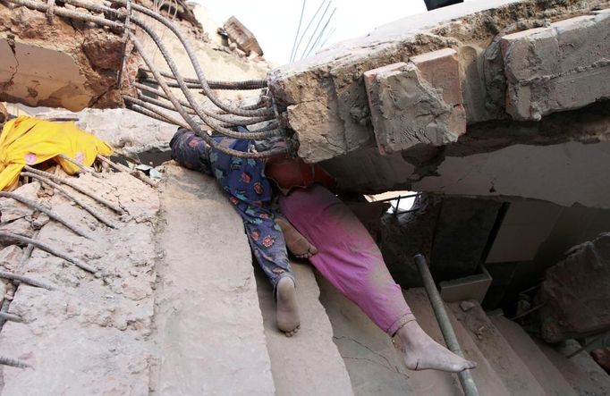 ATTENTION EDITORS - VISUAL COVERAGE OF SCENES OF DEATH OR INJURY Bodies of garment workers are seen among the rubble in the Rana Plaza building which collapsed, in Savar, 30 km (19 miles) outside Dhaka April 24, 2013. A block housing garment factories and shops collapsed in Bangladesh on Wednesday, killing nearly 100 people and injuring more than a thousand, officials said.REUTERS/Andrew Biraj (BANGLADESH - Tags: DISASTER BUSINESS) TEMPLATE OUT Published: Dub. 24, 2013, 3:50 odp.