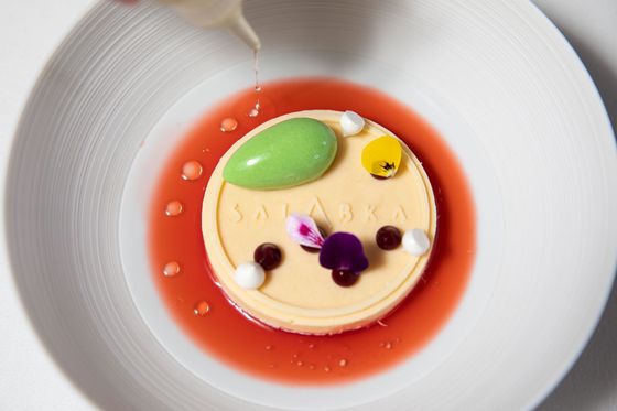 Parfait z bílé čokolády a mandlí s mandlovou drobenkou, šťavelovou zmrzlinou, citronovou pusinkou, jahodovým consommé, vanilkovým olejem a praskacím prachem.