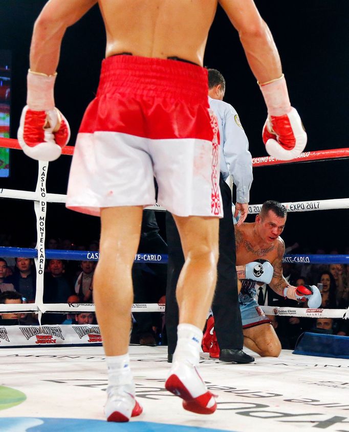 World champion Gennadiy Golovkin of Kazakhstan (L) looks at Martin Murray of England (R), after knocking him down, during the WBA-WBC-IBO Middleweight World Championship