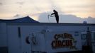 With heavy winds throughout the area, a worker secures a trailer during the Cole Brothers Circus of the Stars stop in Myrtle Beach, South Carolina, March 31, 2013. Traveling circuses such as the Cole Brothers Circus of the Stars, complete with its big top tent, set up their tent city in smaller markets all along the East Coast of the United States as they aim to bring the circus to rural areas. The Cole Brothers Circus, now in its 129th edition, travels to 100 cities in 20-25 states and stages 250 shows a year. Picture taken March 31, 2013. REUTERS/Randall Hill (UNITED STATES - Tags: SOCIETY ENTERTAINMENT) Published: Dub. 1, 2013, 7:01 odp.