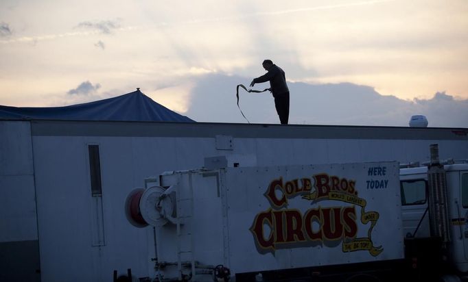 With heavy winds throughout the area, a worker secures a trailer during the Cole Brothers Circus of the Stars stop in Myrtle Beach, South Carolina, March 31, 2013. Traveling circuses such as the Cole Brothers Circus of the Stars, complete with its big top tent, set up their tent city in smaller markets all along the East Coast of the United States as they aim to bring the circus to rural areas. The Cole Brothers Circus, now in its 129th edition, travels to 100 cities in 20-25 states and stages 250 shows a year. Picture taken March 31, 2013. REUTERS/Randall Hill (UNITED STATES - Tags: SOCIETY ENTERTAINMENT) Published: Dub. 1, 2013, 7:01 odp.