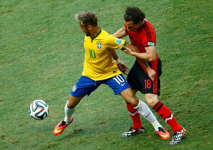 Brazil's Neymar has his arm held on to by Mexico's Andres Guardado (R) during their 2014 World Cup Group A soccer match at the Castelao arena in Fortaleza, June 17, 2014.