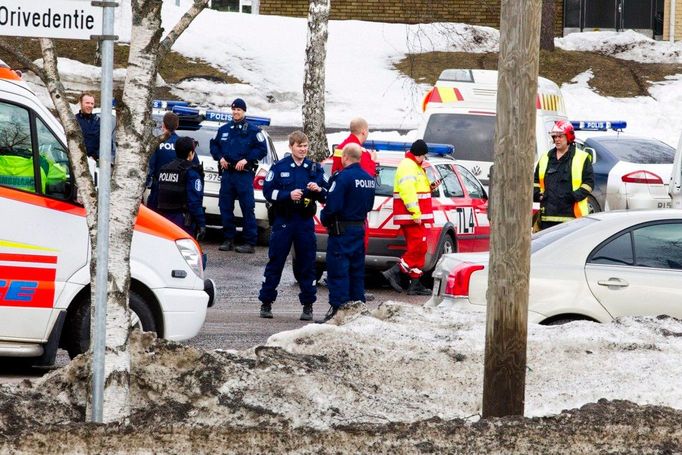 Policisté a zdravotníci stojí před školou, v níž útočník začal střílet.