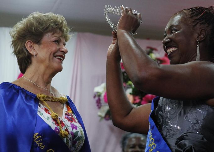 Miss Elderly 2012 Neide Vieira Lapastina (L), 68, is crowned by a woman during an awards ceremony at a beauty contest for elderly women in honour of Mother's Day, in Sao Paulo May 10, 2012. The event was held to promote greater self-esteem among senior citizens, according to organizer Nilton Guedes. REUTERS/Nacho Doce (BRAZIL - Tags: SOCIETY) Published: Kvě. 11, 2012, 3:11 dop.