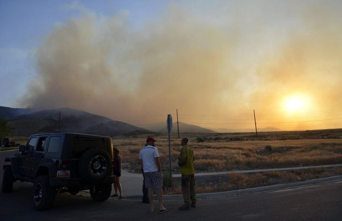 Casey Benson and Brook Chadwick talk about the brush fire near Saratoga Springs, Utah, June 22, 2012. More than 1,000 homes were evacuated from two small Utah communities on Friday as high winds whipped up a brush fire triggered by target shooters and pushed the flames toward houses and a nearby explosives factory. REUTERS/Jeff McGrath (UNITED STATES - Tags: ENVIRONMENT DISASTER) Published: Čer. 23, 2012, 3:49 dop.