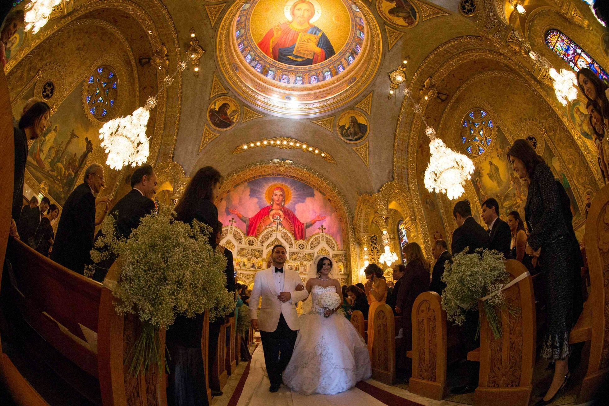 Moshar, who is of Persian, German and Filipino descent, walks down the aisle with her new husband Safar, whose parents are from Syria, at their wedding in Saint Sophia Greek Orthodox Cathedral in Los