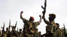 South Sudan's SPLA soldiers hold up their weapons as they shout at a military base in Bentiu