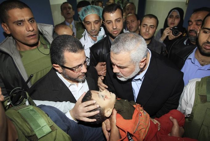 Senior Hamas leader Ismail Haniyeh (2nd R) and Egypt's Prime Minister Hisham Kandil (2nd L) touch the body of a Palestinian boy, who was killed in an Israeli air strike, during a visit to a hospital in Gaza City November 16, 2012. Israel's military denied on Friday that it had carried out attacks in the Gaza Strip during a visit to the enclave by Kandil. REUTERS/Mahmud Hams/Pool (GAZA - Tags: POLITICS CIVIL UNREST TPX IMAGES OF THE DAY) Published: Lis. 16, 2012, 10:29 dop.