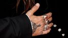 Detail ruky Johnnyho Deppa z červeného koberce.