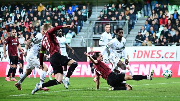 Jakub Martinec ze Sparty ve skluzu zasahuje před hráči Karviné.