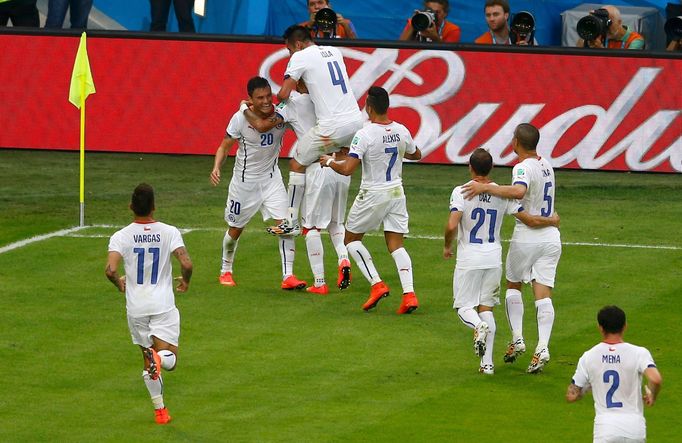 Chile's Charles Aranguiz (20) is congratulated by teammates after his goal during the 2014 World Cup Group B soccer match between Spain and Chile at the Maracana stadium