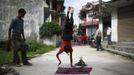 Gchan Choudhary, 17, plays a drum as his younger brother Drumpal Choudhary, 11, performs trick at the streets of Kathmandu August 15, 2012. Gchan and Drumpal, together with their sister, Shivani, came to Kathmandu from India 5 years ago, earn their living by performing tricks on the streets of Kathmandu. According to Drumpal, Shivani's older brother, they earn around $10 a day by performing tricks, which is not enough to feed their 10-member family living together in a small hut without a proper toilet or any basic needs. REUTERS/Navesh Chitrakar (NEPAL - Tags: SOCIETY POVERTY IMMIGRATION) Published: Srp. 15, 2012, 4:14 odp.