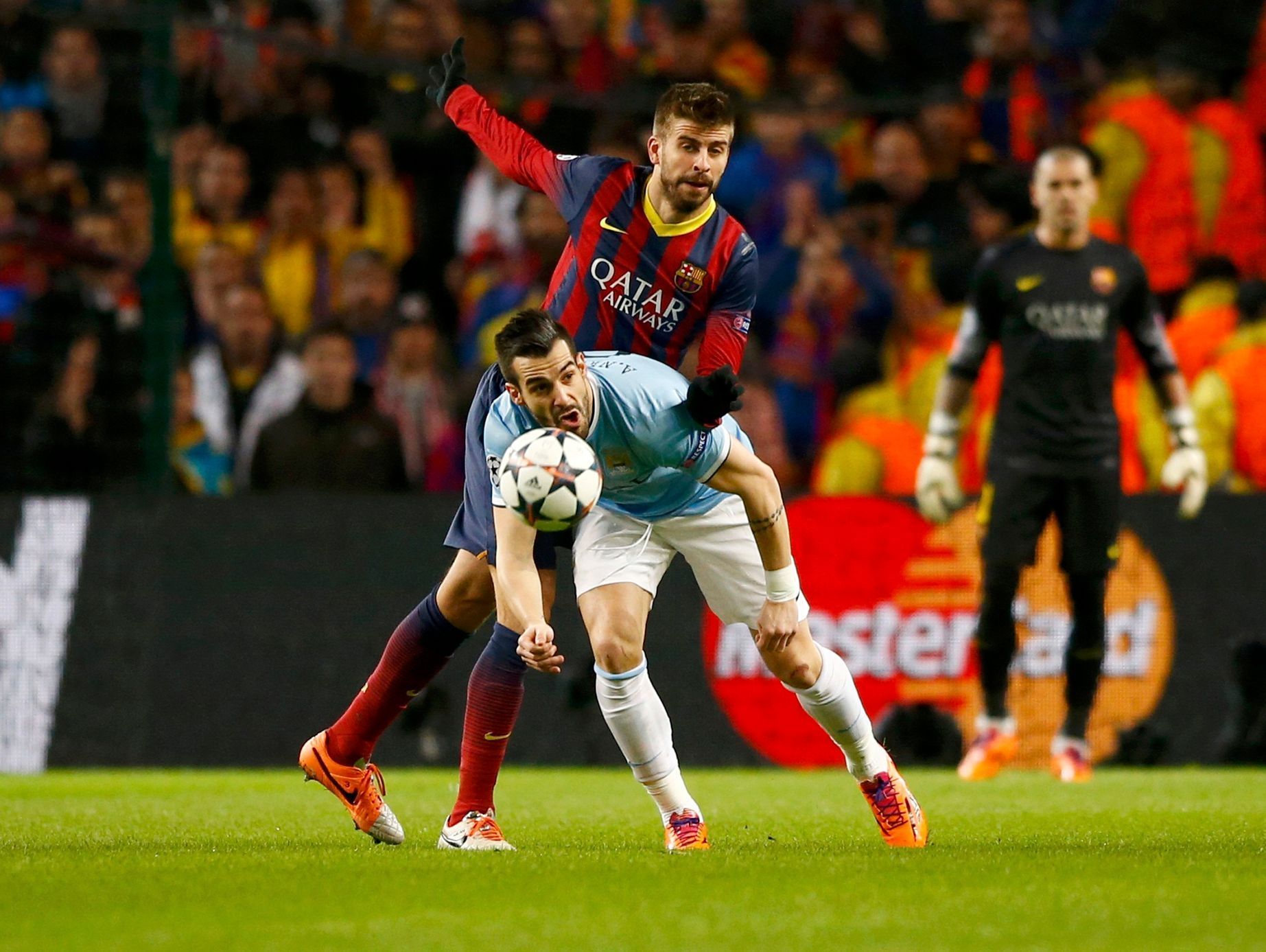 Manchester City's Alvaro Negredo is challenged by Barcelona's Gerard Pique during their Champions League round of 16 first leg soccer match at the Etihad Stadium in Manchester