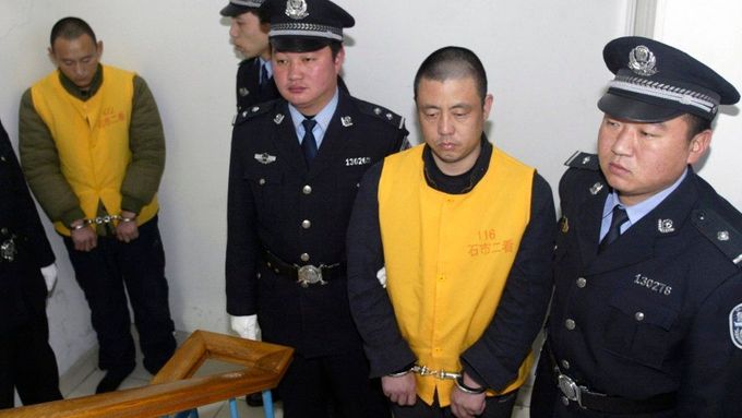 Dva z obžalovaných v tzv. melaminovém skandálu - Čang Jü-ťün a Čang Jen-čang (zcela vlevo) - čekají, až budou předvedeni před soud v čínském městě Š'-ťia-čuang