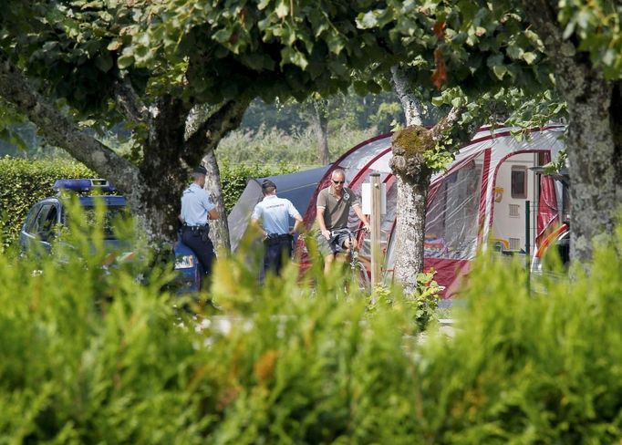 French gendarmes stand guard next to a caravan at Saint-Jorioz camping ground, near Annecy, southeastern France, September 6, 2012. French police have found a four-year-old girl alive inside a British-registered BMW car where they discovered three people shot dead outside the village of Chevaline on Wednesday, September 5, a public prosecutor said. A fourth body, apparently a person who had been riding a bicycle, was found nearby. A badly injured eight-year-old girl, also found nearby, was taken to hospital by helicopter. REUTERS/Robert Pratta (FRANCE - Tags: CRIME LAW) Published: Zář. 6, 2012, 11:49 dop.