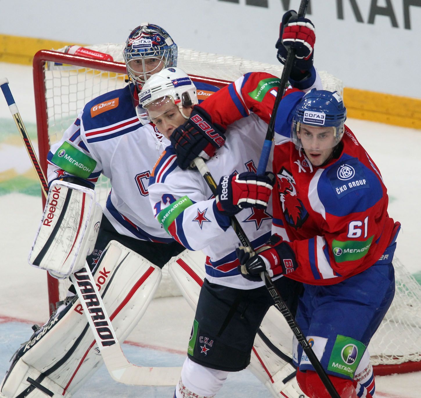 Hokejista Lva Praha Erik Christensen v souboji s Ivanem Něprjajevem před Sergejem Bobrovským v utkání KHL proti SKA Petrohradu.