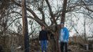 Lisa Perez and her neighbour Edward Perez pose for a photograph next to the tree that both were separately swept into by rushing storm surge waters when Hurricane Sandy struck in Oakwood Beach, Staten Island November 14, 2012. Lisa, who lives in a single-story home raised eight feet above the ground, was swept into the water when she tried to move her car to higher ground, said, "I felt myself drowning and was screaming to my daughter, if I die, just stay there!" At the same moment, neighbour Eddie Perez was also swept into the water trying to escape his home. Eddie yelled at Lisa, now holding on to a log to "go for the tree." The two climbed onto the tree where they spent close to two hours at the height of the storm unable to move. Picture taken November 14, 2012. REUTERS/Mike Segar (UNITED STATES - Tags: DISASTER ENVIRONMENT) ATTENTION EDITORS PICTURE 09 OF 19 FOR PACKAGE 'SURVIVING SANDY' SEARCH 'SEGAR SANDY' FOR ALL PICTURES Published: Lis. 20, 2012, 3:30 odp.