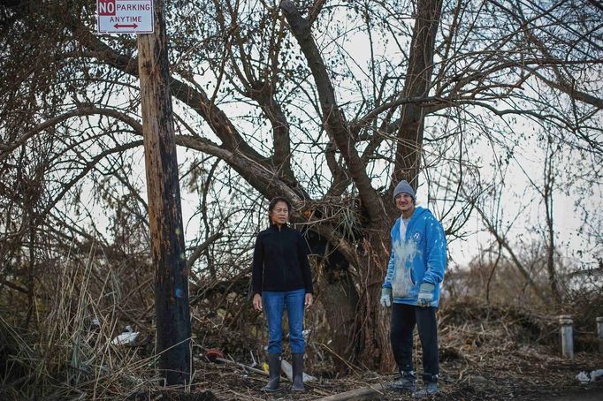 Lisa Perez and her neighbour Edward Perez pose for a photograph next to the tree that both were separately swept into by rushing storm surge waters when Hurricane Sandy struck in Oakwood Beach, Staten Island November 14, 2012. Lisa, who lives in a single-story home raised eight feet above the ground, was swept into the water when she tried to move her car to higher ground, said, "I felt myself drowning and was screaming to my daughter, if I die, just stay there!" At the same moment, neighbour Eddie Perez was also swept into the water trying to escape his home. Eddie yelled at Lisa, now holding on to a log to "go for the tree." The two climbed onto the tree where they spent close to two hours at the height of the storm unable to move. Picture taken November 14, 2012. REUTERS/Mike Segar (UNITED STATES - Tags: DISASTER ENVIRONMENT) ATTENTION EDITORS PICTURE 09 OF 19 FOR PACKAGE 'SURVIVING SANDY' SEARCH 'SEGAR SANDY' FOR ALL PICTURES Published: Lis. 20, 2012, 3:30 odp.