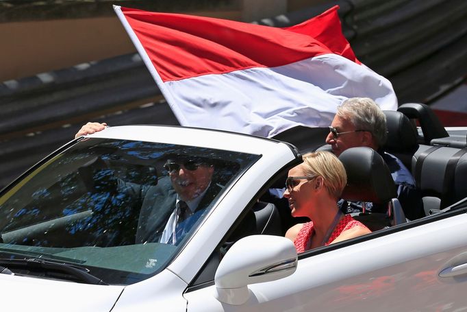 Prince Albert II of Monaco (L) and Princess Charlene are seen in a car with a Monaco flag ahead of the Monaco F1 Grand Prix May 26, 2013. REUTERS/Benoit Tessier (MONACO -