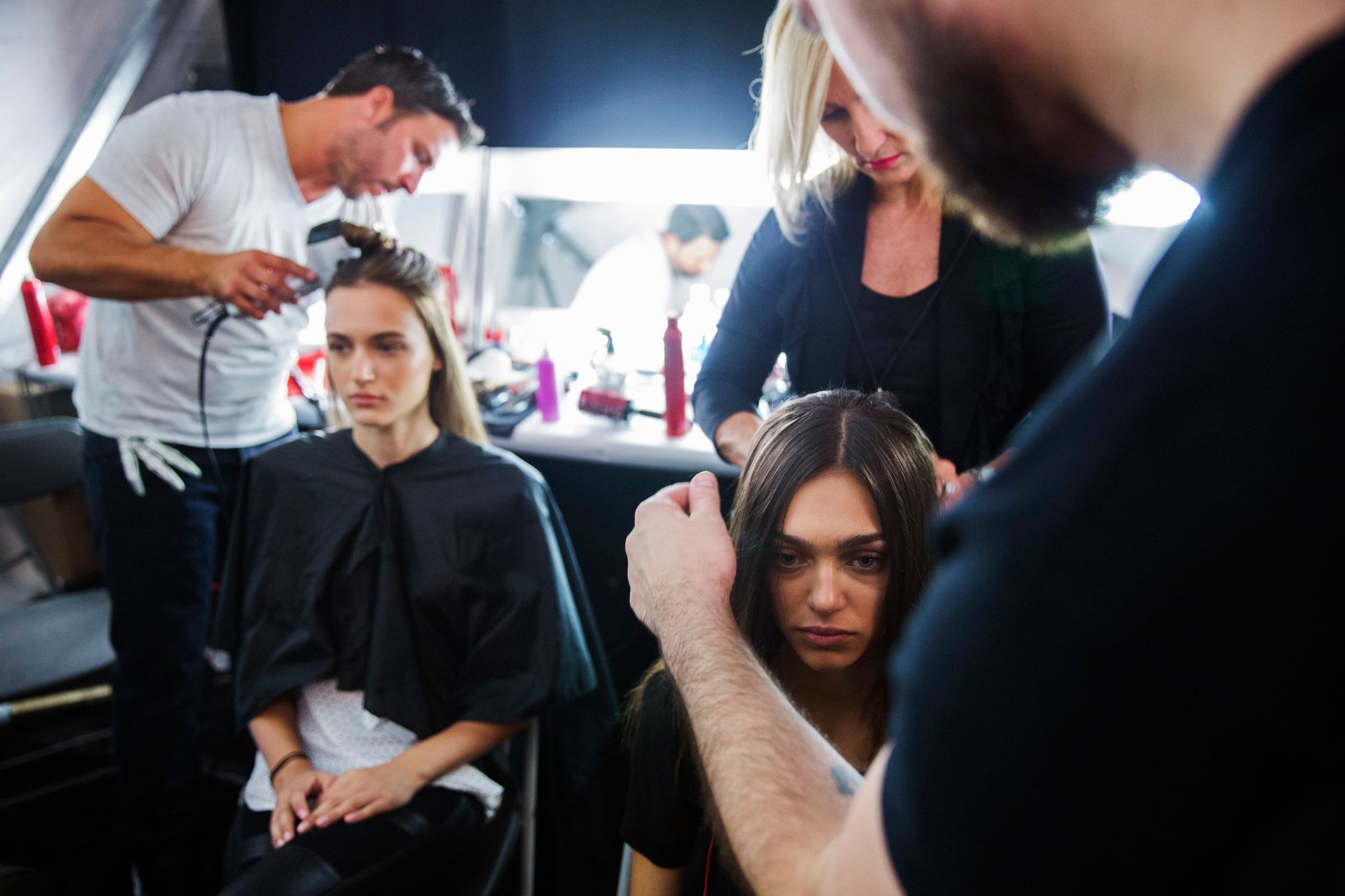 Models have their hair done backstage before presenting the BCBG Max Azria collection during New York Fashion Week