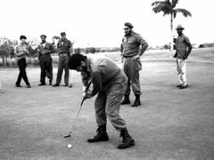Historická fotografie, zachycující Che Guevaru (s holí v ruce) a Fidela Castra (s brýlemi a baretem na hlavě) na golfu v březnu 1961.